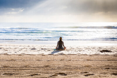Tranquil woman sitting looking at ocean